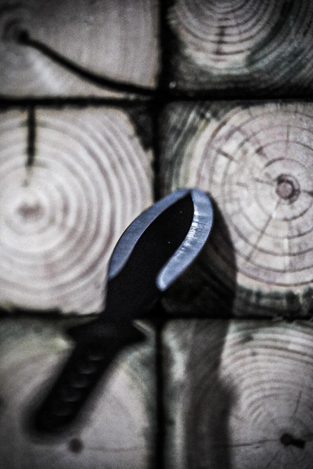 Throwing knives stuck in a wooden target board