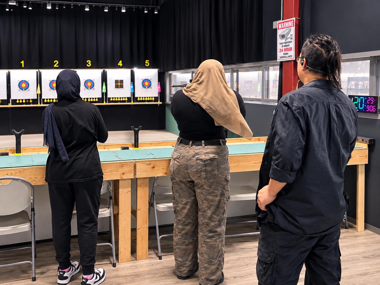 A coach giving airgun instruction on the airgun range at OnPoint Archery